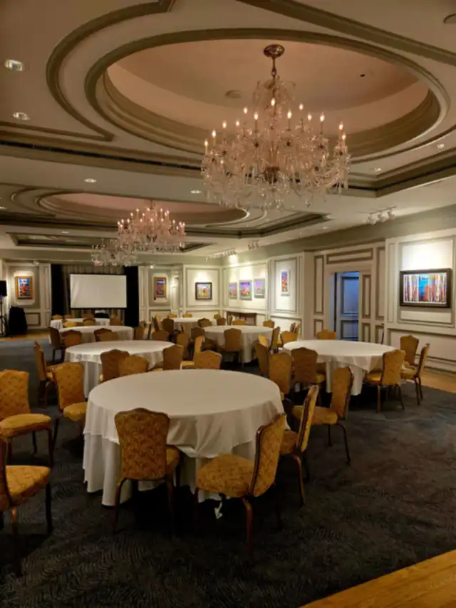 A banquet hall with chandeliers and round tables