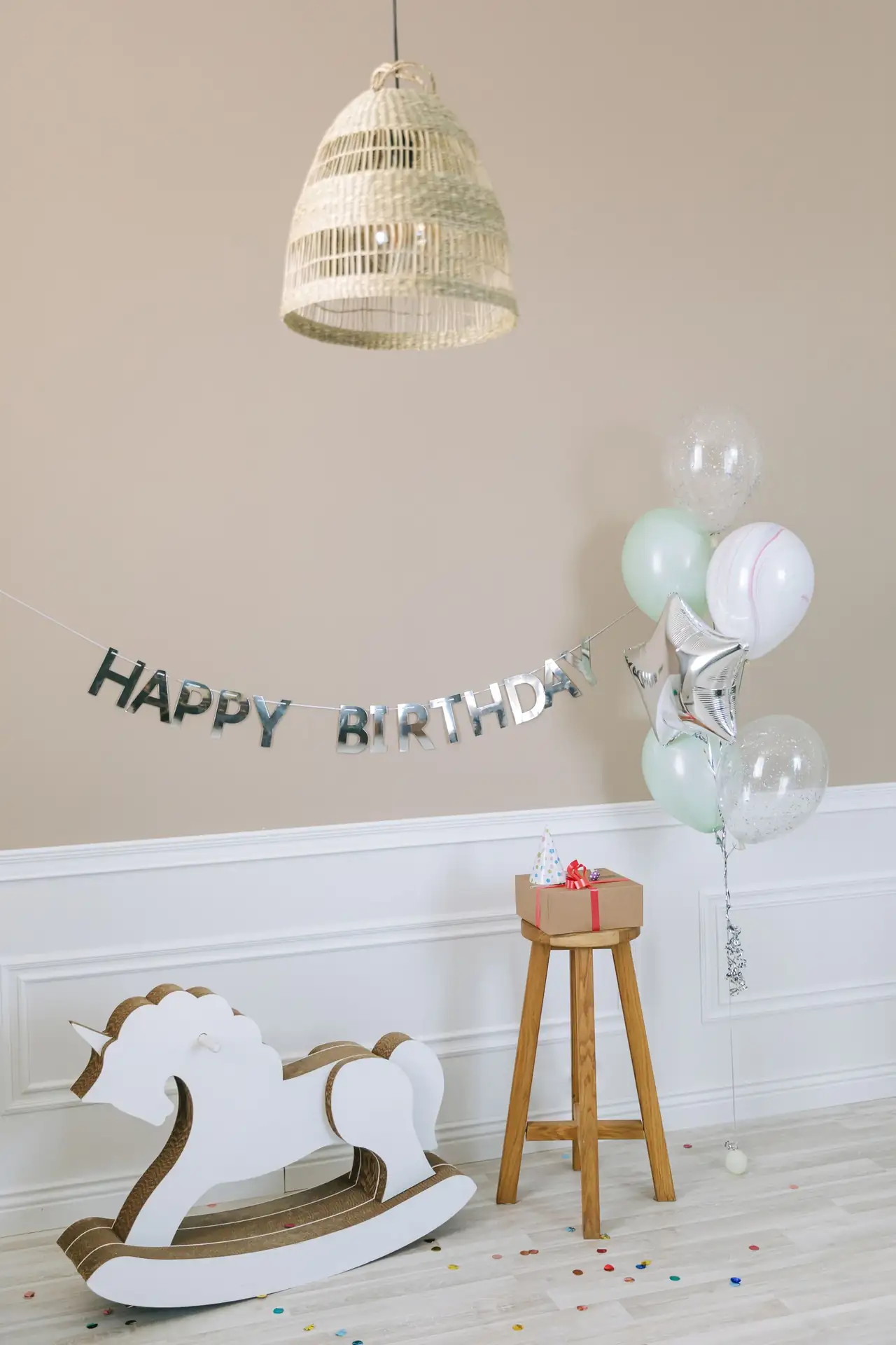 Balloons, a birthday banner and a rocking horse